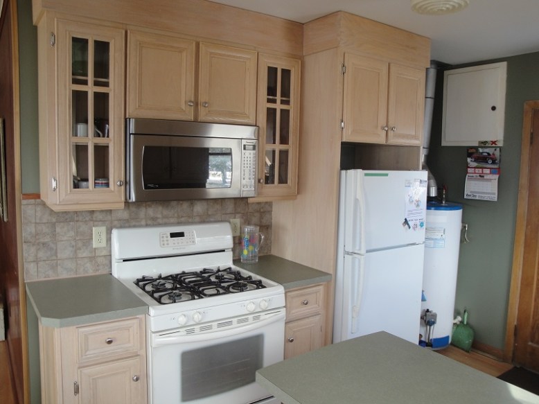 Newly renovated kitchen includes microwave, fridge and freezer, gas stove and oven, dishes, pots, pans, cutlery and more.